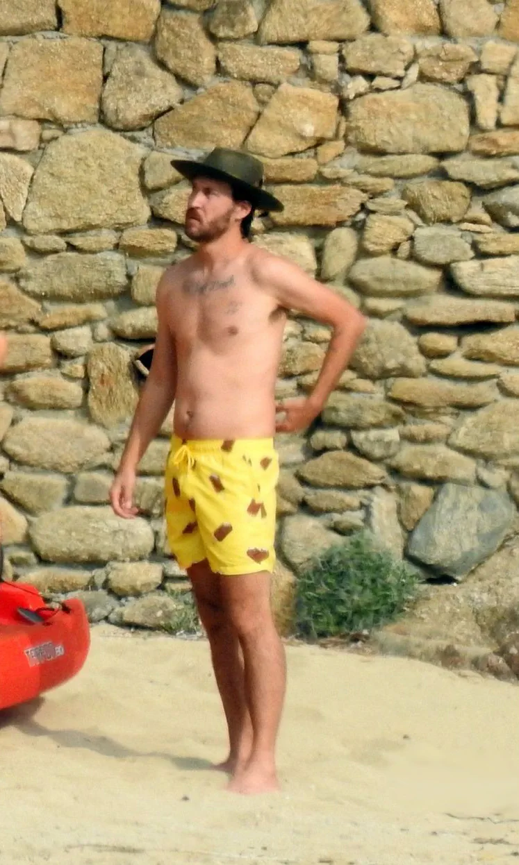 ダニー・フジカワはビーチで上半身裸で日光浴をしています